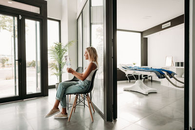 Relaxed woman waiting for pressotherapy treatment at wellness center or clinic