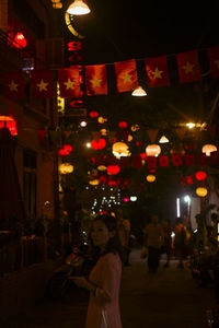 Woman standing in illuminated city at night