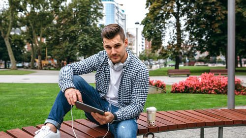 Young man using mobile phone while sitting outdoors