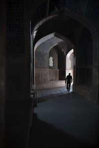 Rear view of man walking in corridor of building