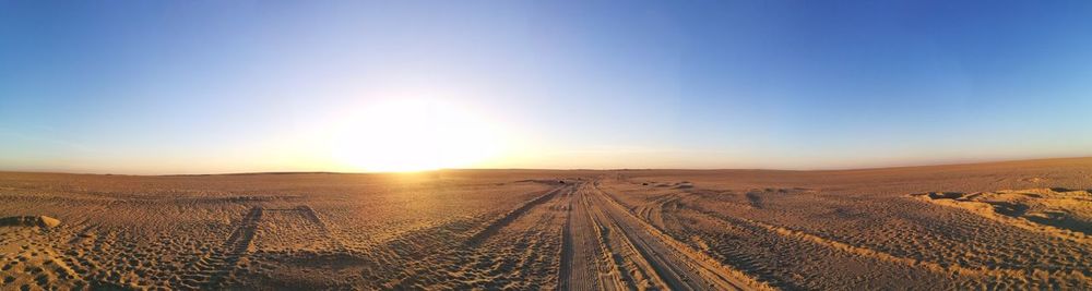 Scenic view of desert against clear blue sky