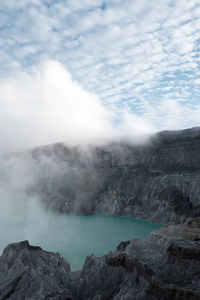 Smoke emitting from volcanic mountain against sky