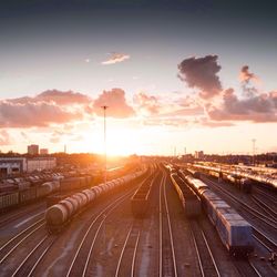 High angle view of trains on tracks against cloudy sky during sunset