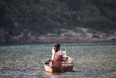 Rear view of woman fishing in lake