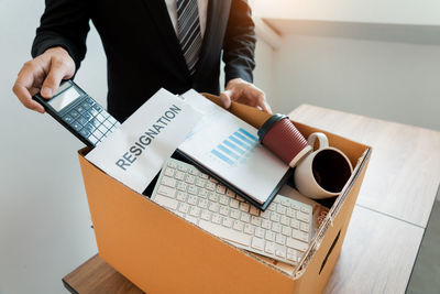 High angle view of man holding coffee cup on table