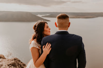 Rear view of couple standing at beach