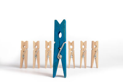 Close-up of clothespins on clothesline against white background