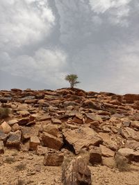 Stack of rocks on landscape against sky