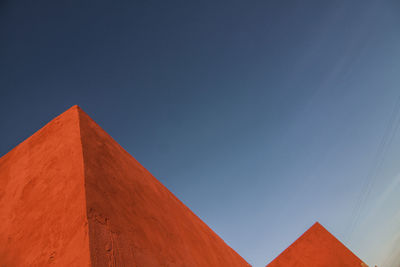 Low angle view of orange building against sky