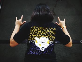 Rear view of woman standing against wall