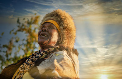 Low angle view of man looking away against sky