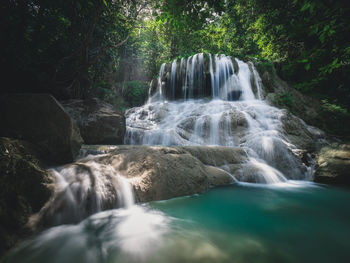 Scenic waterfall smooth stream, turquoise pond in rainforest. erawan falls, kanchanaburi, thailand.