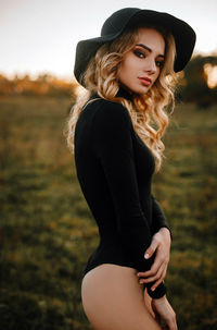 Beautiful young woman in hat on field