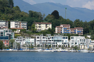 Buildings by sea against mountain