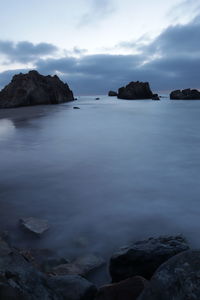 Scenic view of rocks in sea against sky