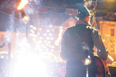 Rear view of man working at night