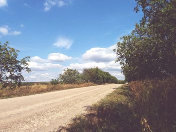 Road amidst field against sky