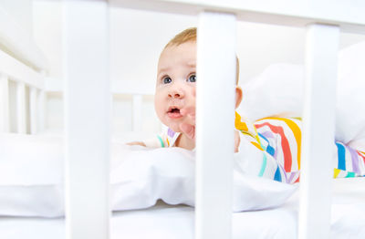 Cute baby boy sleeping on bed at home