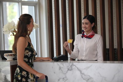 Happy young woman standing on table