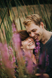 Couple embracing while laughing by plants