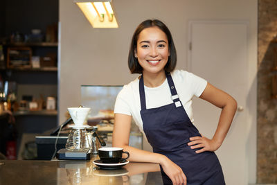 Portrait of young woman sitting on table