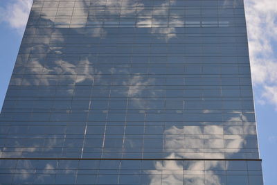 Low angle view of glass building against sky