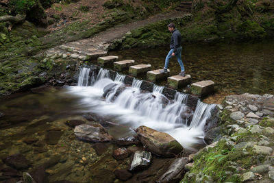 High angle view of man walking on stone bridge over shimna river