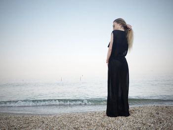 Rear view of full length woman standing on beach