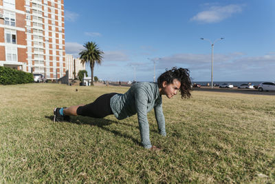 Woman doing push ups on the grass.