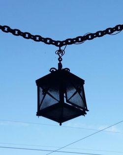 Low angle view of chain against blue sky