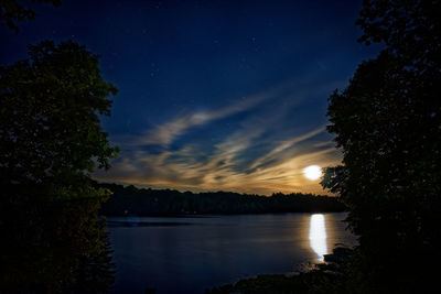 Scenic view of lake against sky at night