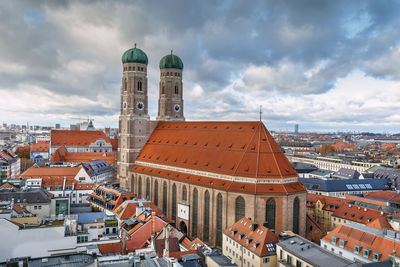 Buildings in city against cloudy sky