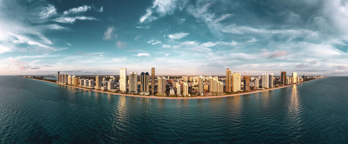 Panoramic view of sea and buildings against sky