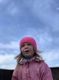 Portrait of cute girl standing against pink sky