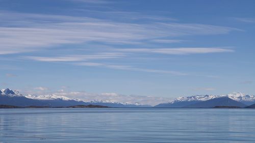 Scenic view of lake by snowcapped mountains against sky