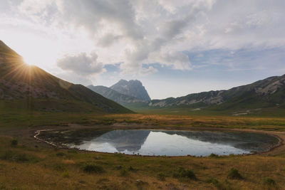 Scenic view of lake and mountains against sky