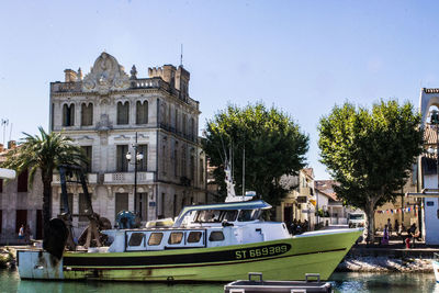 Boats moored at waterfront against sky