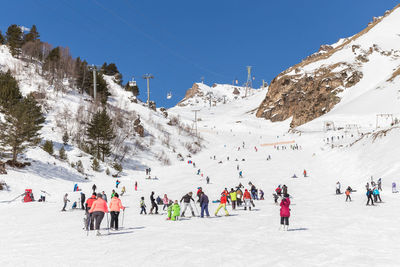 People skiing on snowcapped mountains during winter