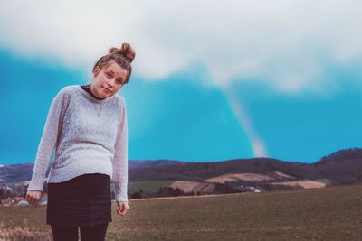 Pregnant woman standing on mountain against sky