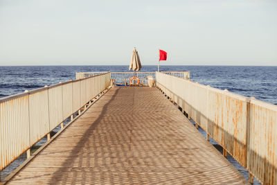 Pier on beach against sky