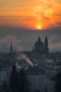 High angle view of silhouette buildings against sky during sunset