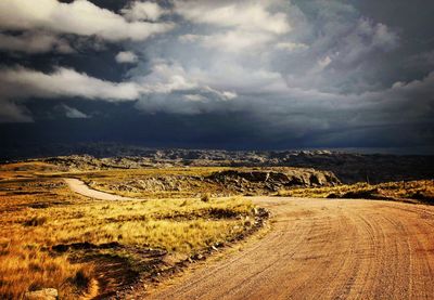 Scenic view of agricultural field against dramatic sky