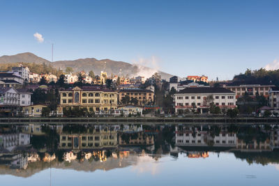 Reflection of buildings in lake against sky