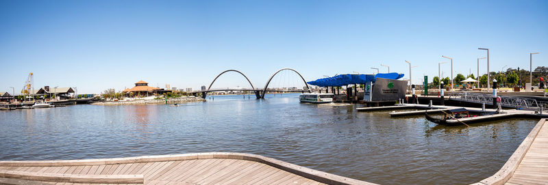 Bridge over river against clear blue sky