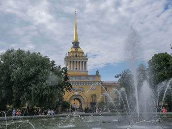 Fountain in city against sky