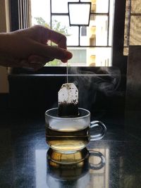 Person holding tea cup on table