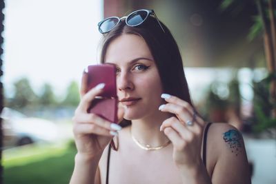 Close-up of young woman checking make-up