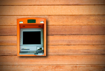 Close-up of atm on wooden wall