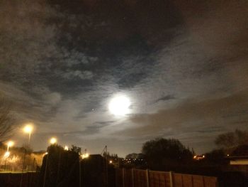 View of illuminated city against cloudy sky