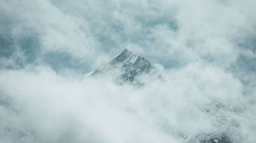 Low angle view of mountain peak against cloudy sky